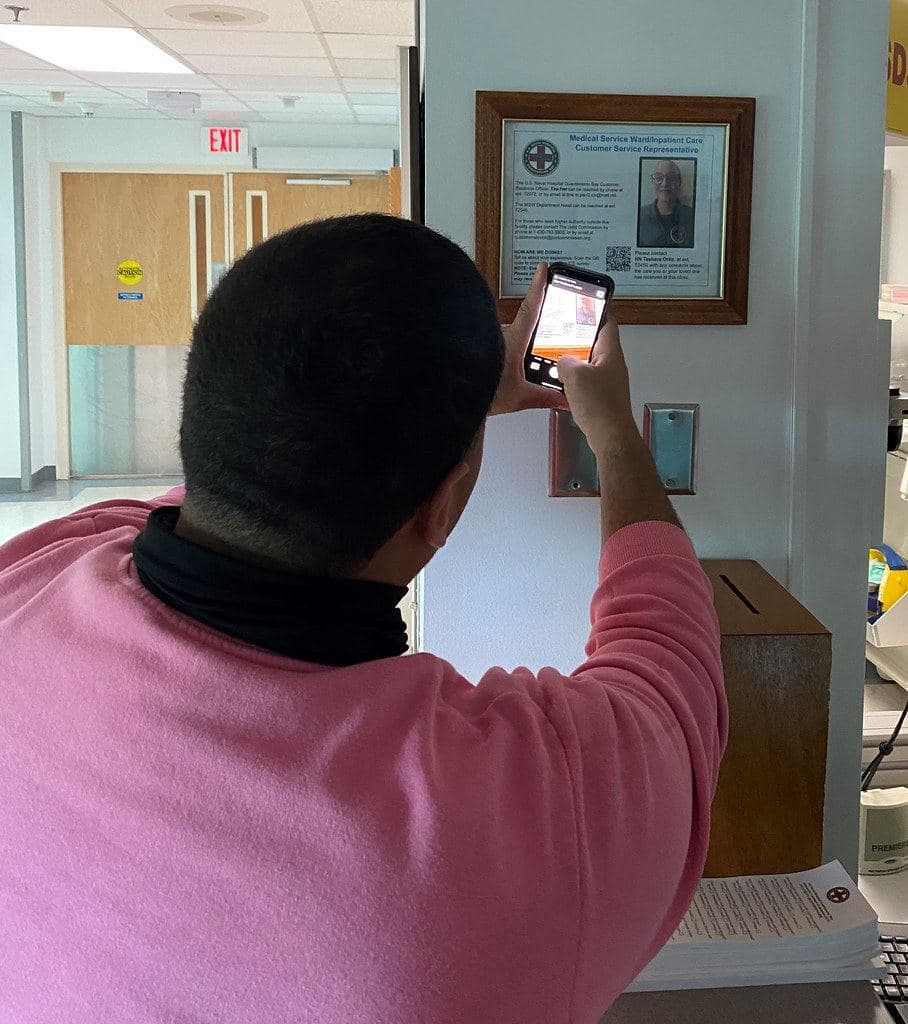 Une personne tend son téléphone vers une affiche pour la scanner
