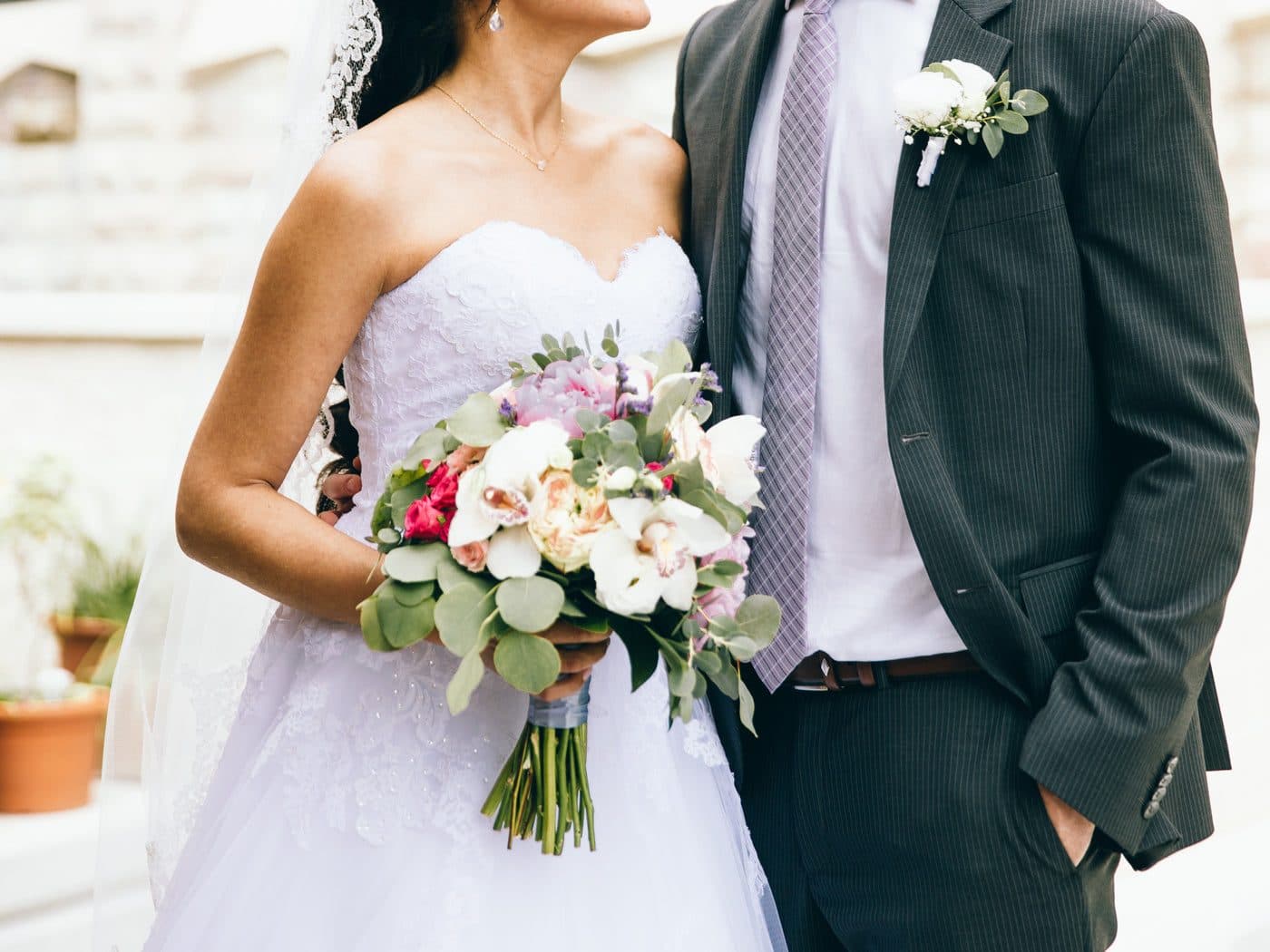 Des mariés côte à côte, le bouquet à la main