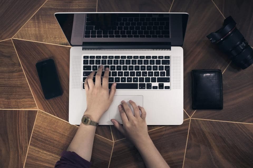 Un ordinateur portable et un appareil photo posés sur un bureau