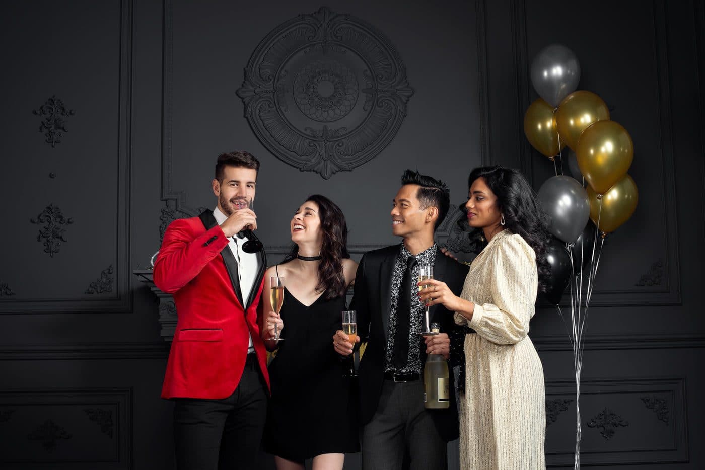 Quatre invités discutent, coupes de champagne à la main