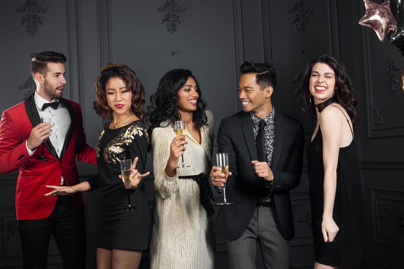 Cinq invités en tenue de soirée, une coupe à la main