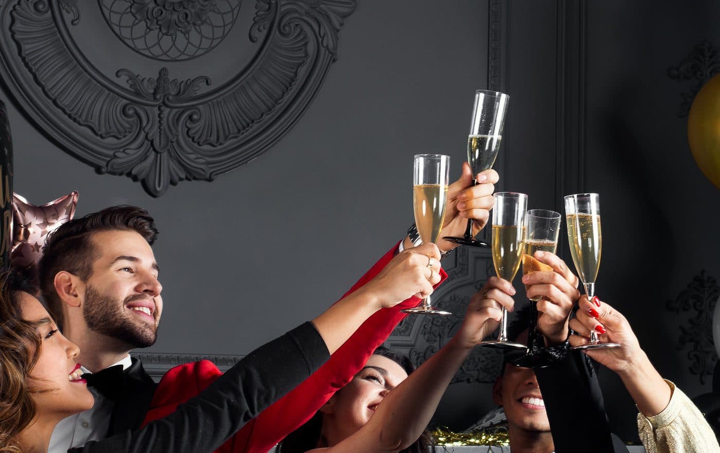 Des invités souriants trinquent, coupes levées